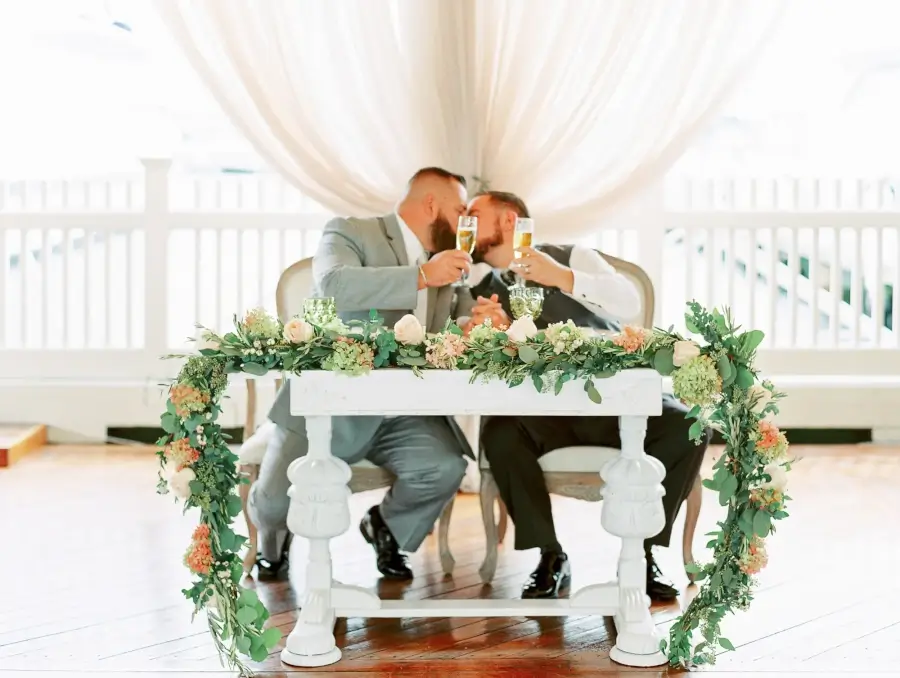 Husbands enjoy a toast at their regatta place newport wedding